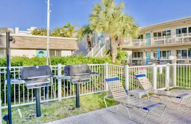 a view of a patio with couches chairs and wooden floor