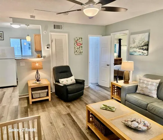 a living room with furniture and a wooden floor