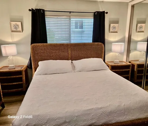 a bedroom with a large bed and wooden floor