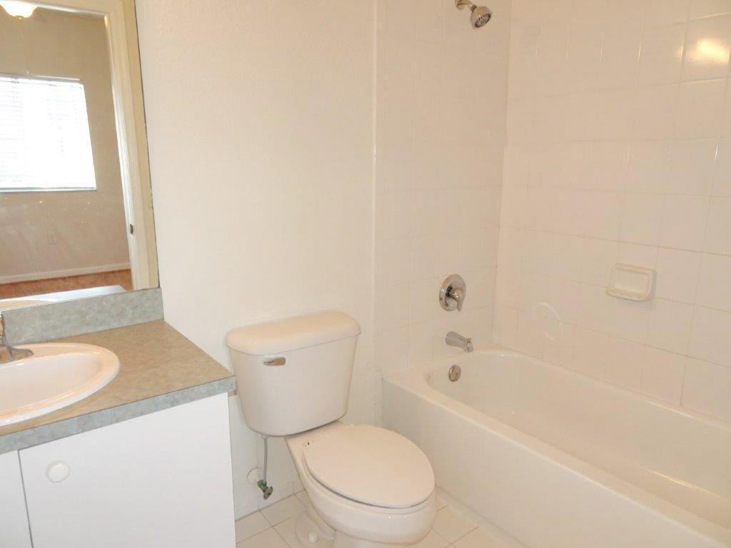 5927 Riverside Avenue Tamarac, FL 33321 - Photo 12 of 15 a bathroom with a granite countertop toilet a sink and a bathtub