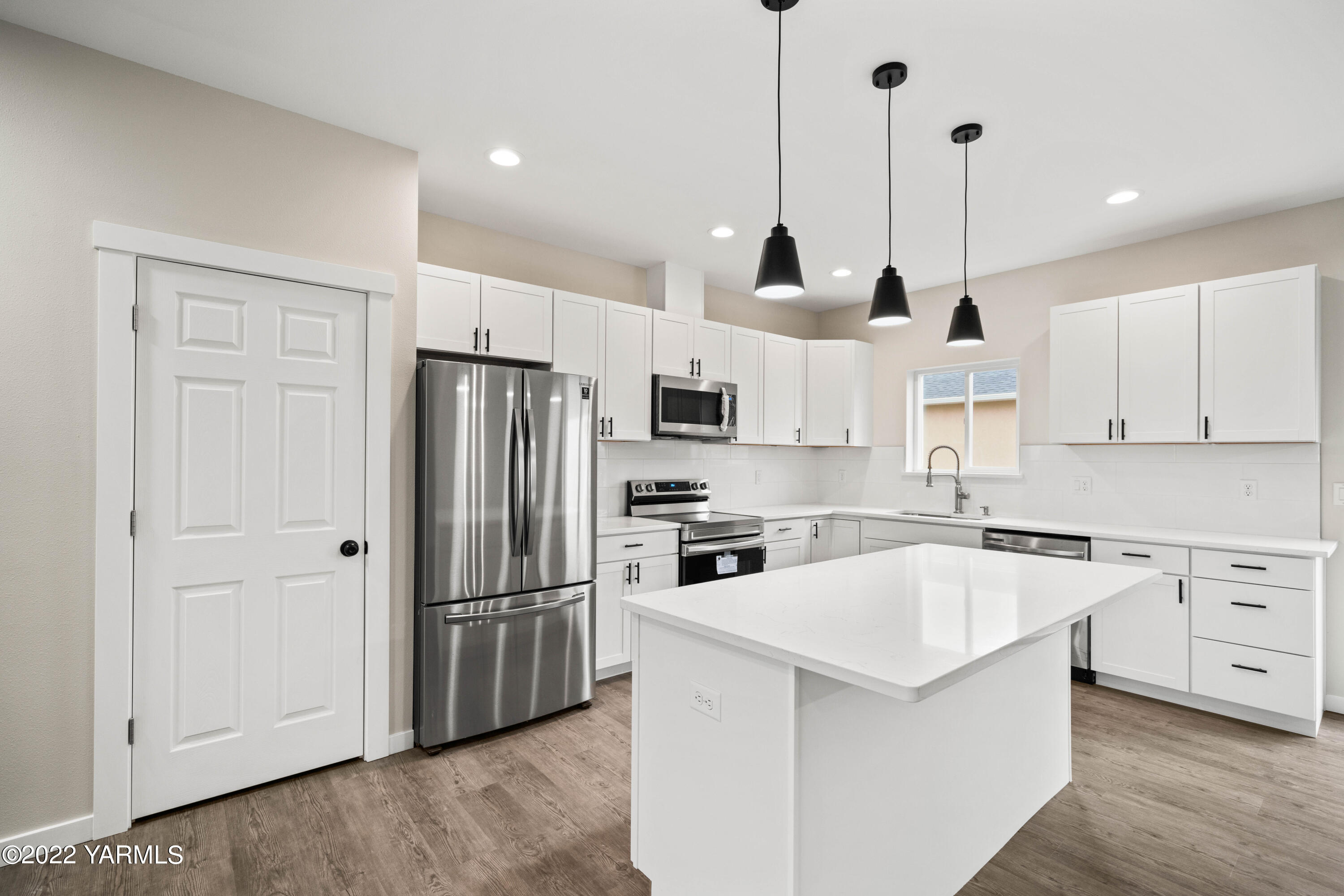 599 Bagley Road Granger, WA 98932 - Photo 3 of 13 a kitchen with stainless steel appliances granite countertop a refrigerator a sink a stove and white cabinets