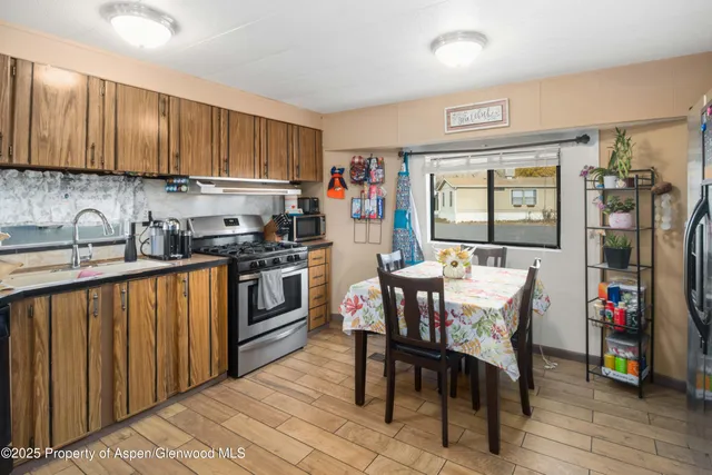 a kitchen with a table chairs stove and cabinets