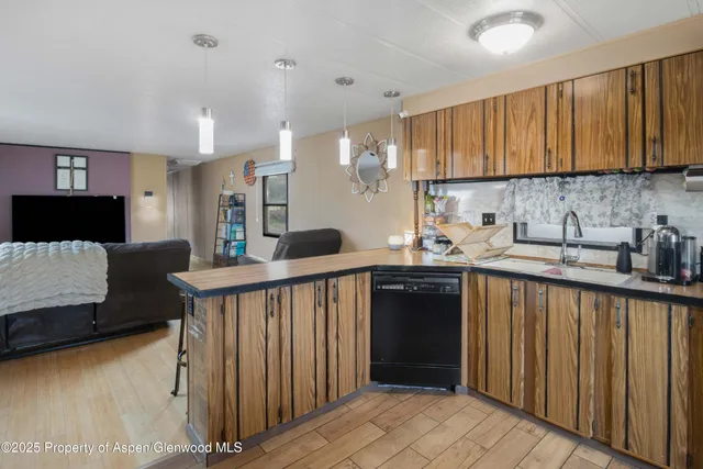 a kitchen with stainless steel appliances granite countertop a refrigerator a sink dishwasher a stove and white cabinets