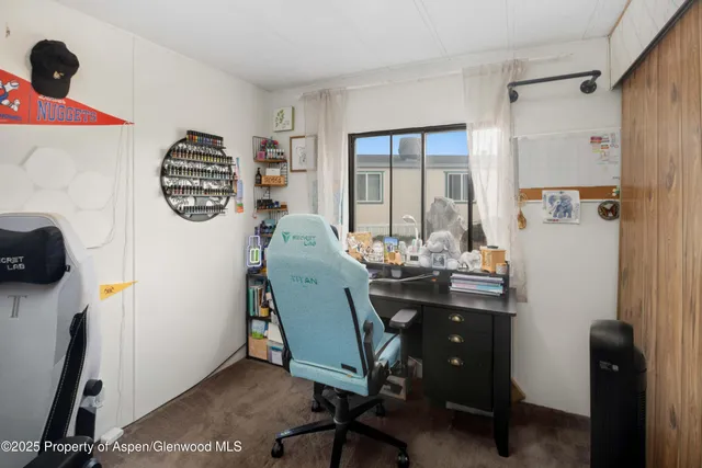 a view of a workspace with furniture and a window