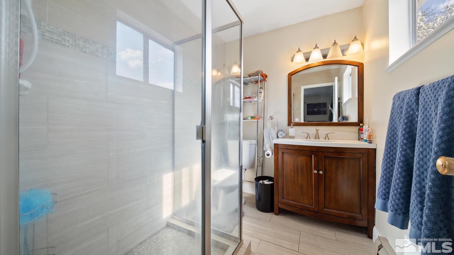 1360 Faland Way Reno, NV 89503 - Photo 21 of 26 a bathroom with a granite countertop sink a mirror and shower