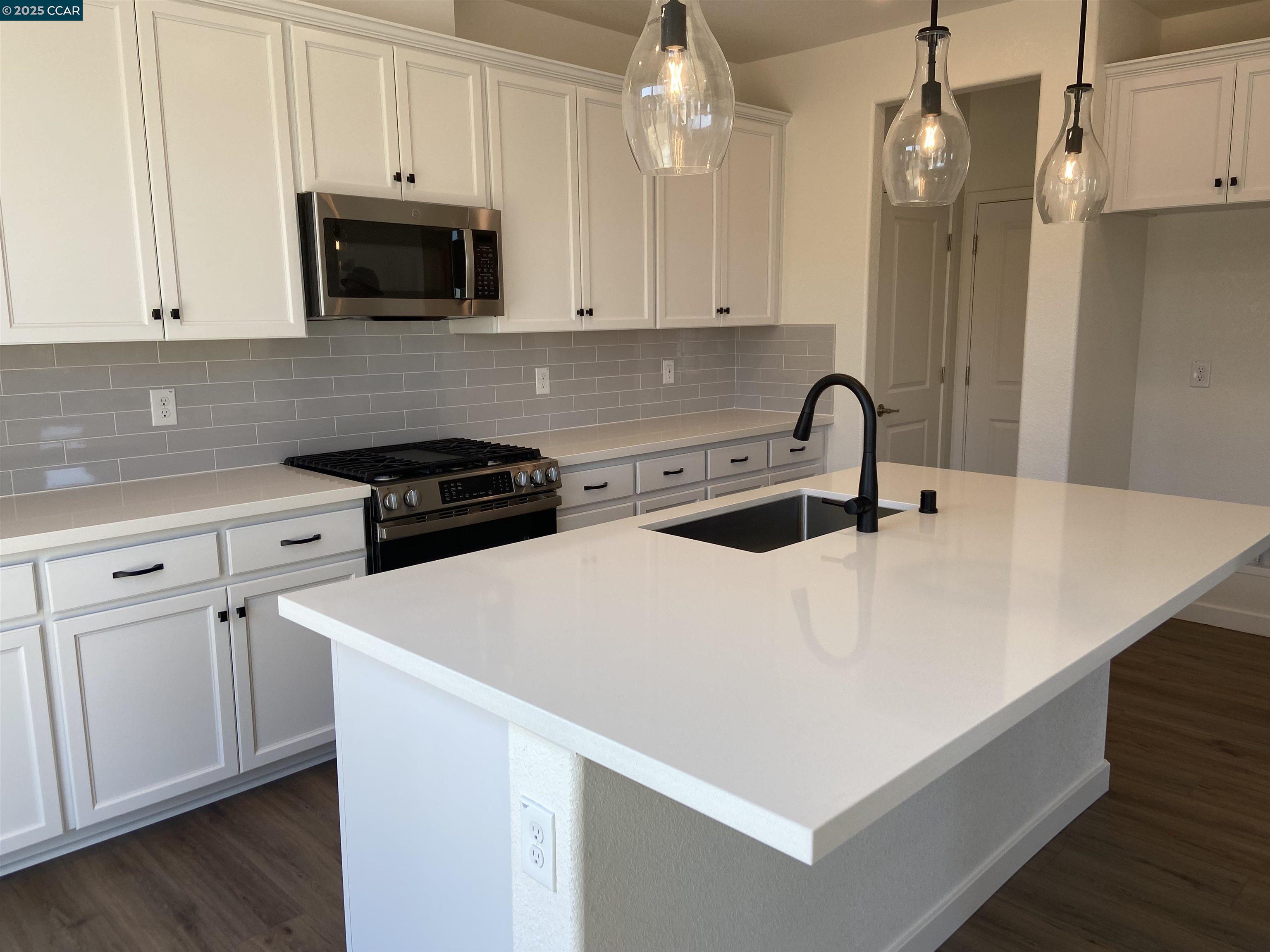 4786 Cantrell Drive Folsom, CA 95630 - Photo 11 of 30 a kitchen with stainless steel appliances a white stove top oven a sink a microwave and cabinets