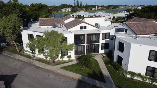 an aerial view of residential houses with outdoor space and parking