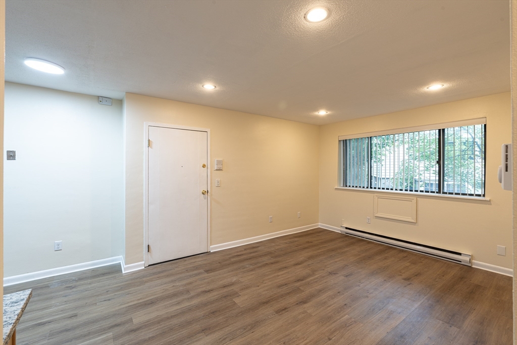 197 Calumet Street, Unit 12 Boston, MA 02120 - Photo 2 of 11 a view of an empty room with wooden floor and a window