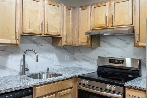 a kitchen with granite countertop a sink and cabinets