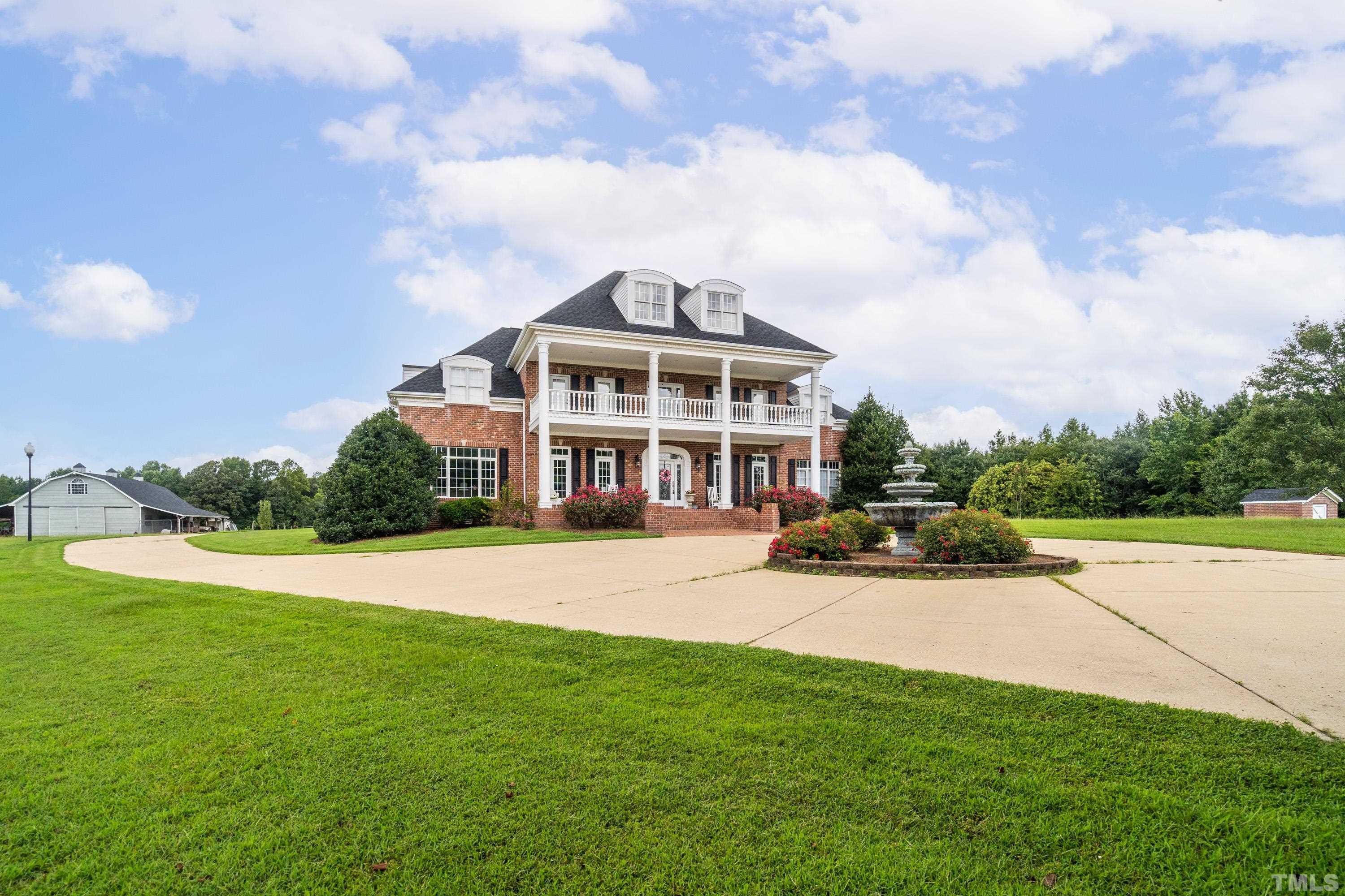 a view of a house with a big yard and large trees