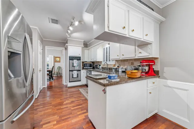 a kitchen with granite countertop a refrigerator sink and cabinets