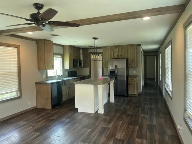 a kitchen with a refrigerator a sink dishwasher with a dining table and chairs
