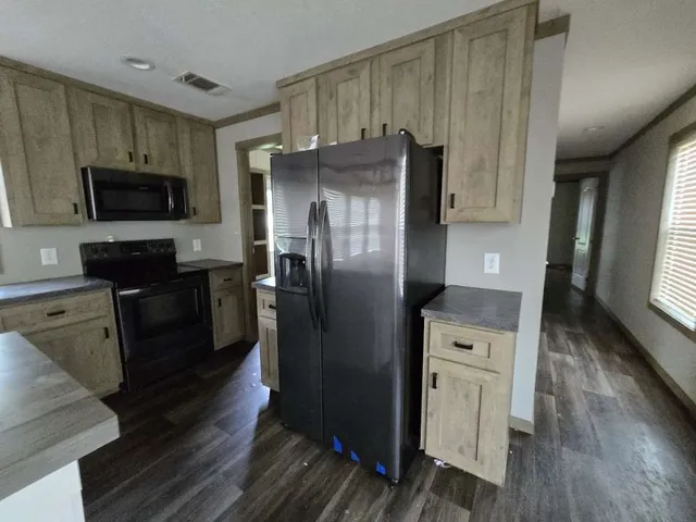 a kitchen with a refrigerator microwave and stove top oven