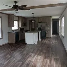 a kitchen with stainless steel appliances granite countertop a refrigerator a sink and a stove