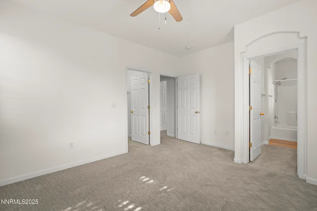 a view of an empty room and a chandelier fan