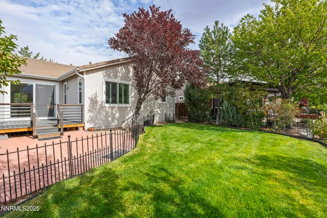 a view of a house with backyard and a tree