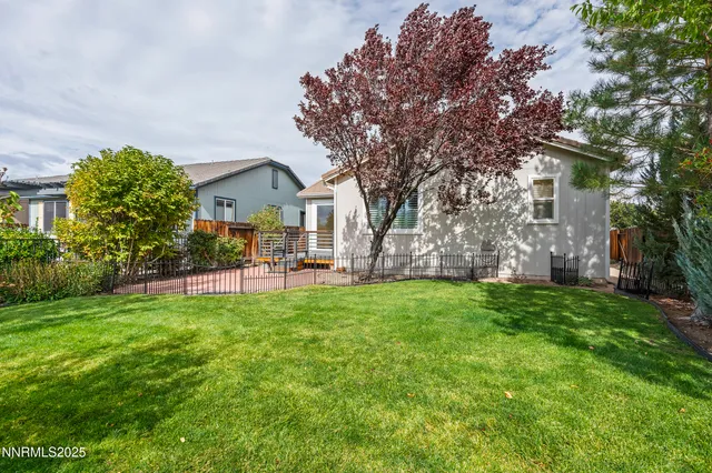 a view of a house with a big yard and large trees