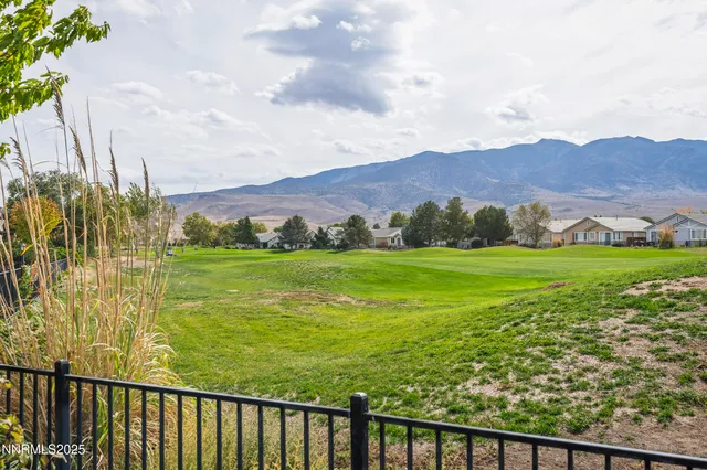 a view of an ocean with houses lake and mountain view in back