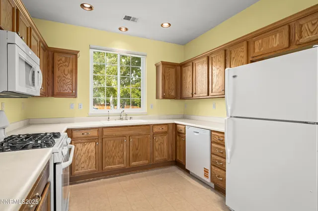 a kitchen with a sink a stove a refrigerator and cabinets