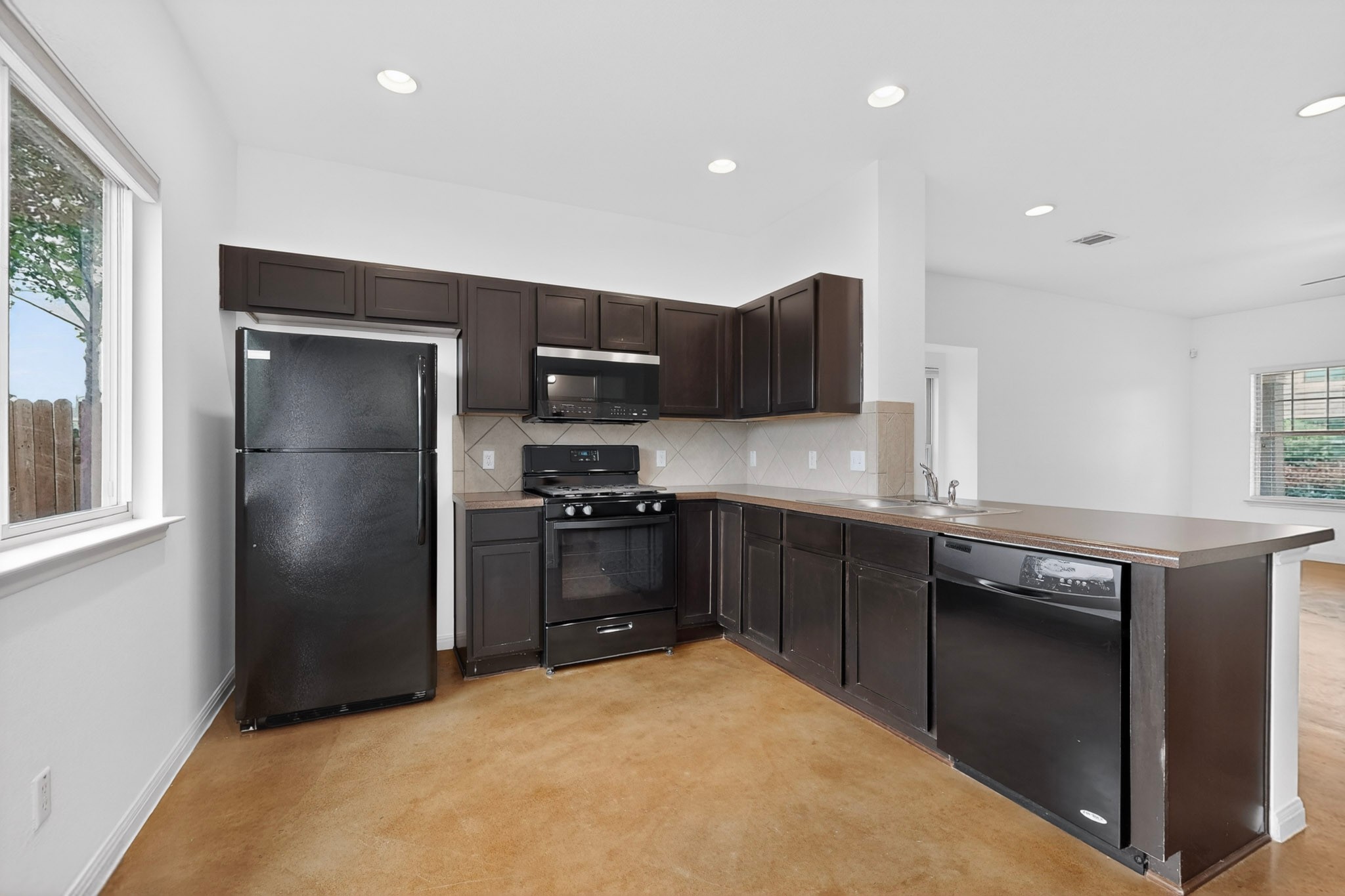 4619 Inicio Lane Austin, TX 78725 - Photo 9 of 32 a kitchen with stainless steel appliances granite countertop a refrigerator a stove a sink and a microwave