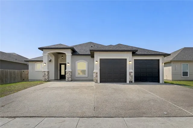 a front view of a house with a yard and garage