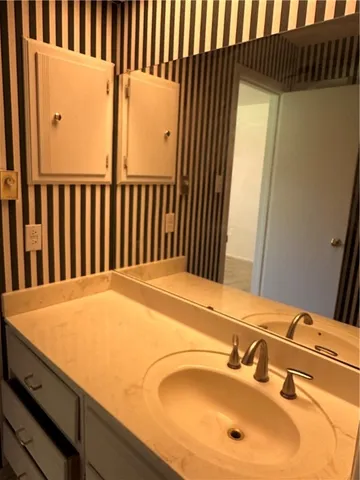 a bathroom with a granite countertop sink and a mirror