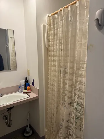 a bathroom with a sink a mirror and a shower curtain