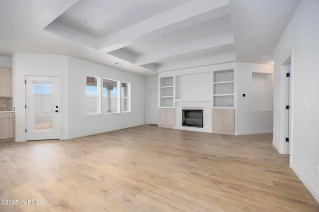 a view of empty room with wooden floor and fireplace