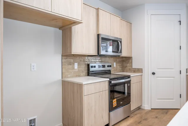 a kitchen with stainless steel appliances granite countertop a stove and a microwave