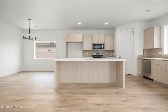 a large kitchen with stainless steel appliances granite countertop a stove a sink and a refrigerator