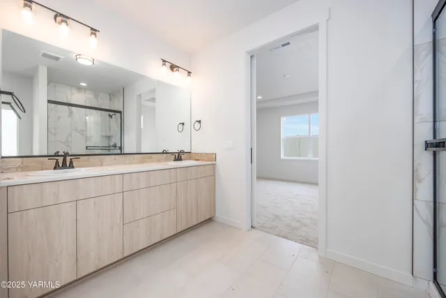 a spacious bathroom with a double vanity sink and a mirror