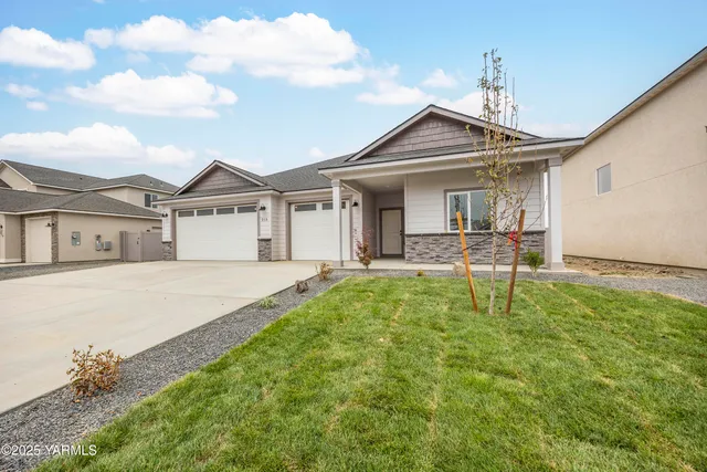 a front view of a house with a garden and yard