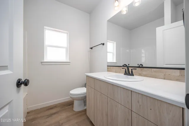 a bathroom with a granite countertop sink a toilet and a mirror
