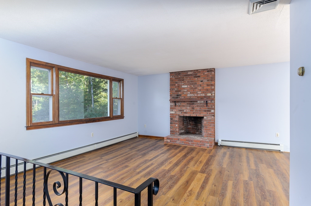 280 South Barre Road Barre, MA 01005 - Photo 8 of 25 an empty room with a fireplace and windows