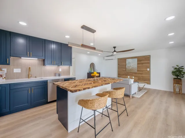 a kitchen with a stove a window and chairs