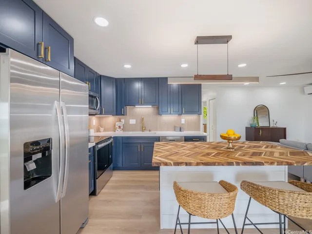 a kitchen with stainless steel appliances granite countertop a sink refrigerator and cabinets