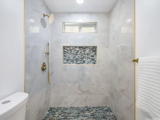 a bathroom with a toilet and a shower
