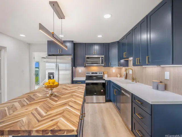 a kitchen with stainless steel appliances granite countertop a sink a stove and a refrigerator