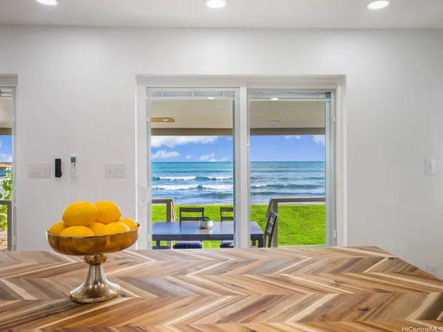 a view of an empty room with a window and kitchen view