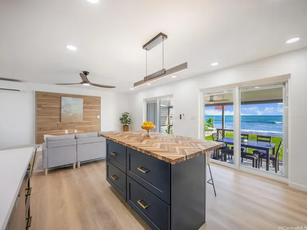a dining hall with stainless steel appliances granite countertop a stove and a wooden floors
