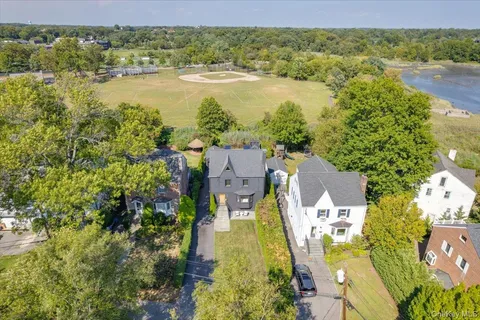 an aerial view of residential houses with outdoor space and river