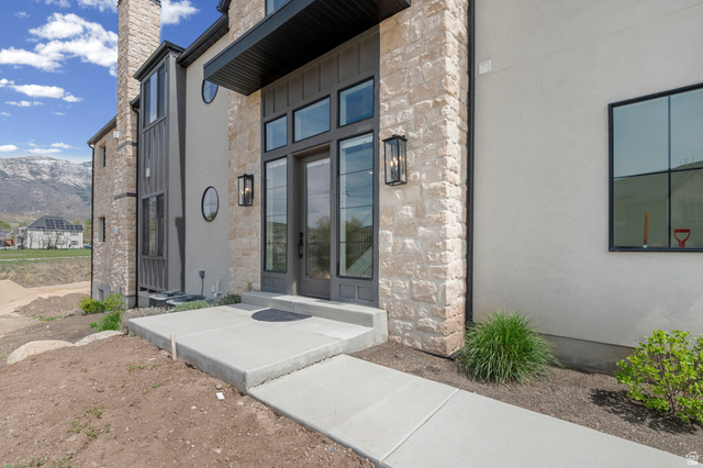 250 South Main Street, Unit 24 Alpine, UT 84004 - Photo 5 of 50 View of exterior entry featuring stone siding, a mountain view, and a chimney