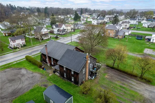 an aerial view of a house with yard green space and mountain view in back