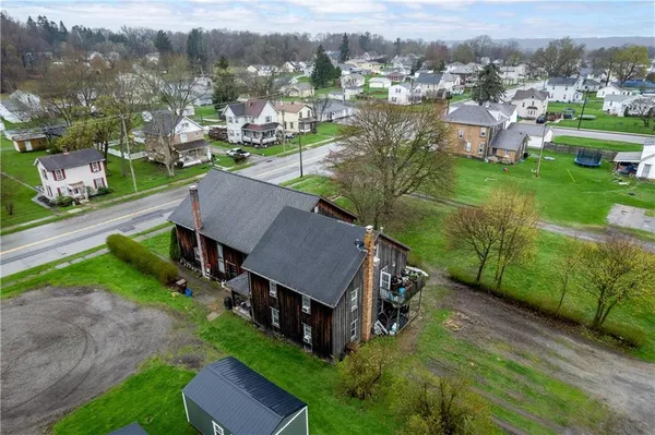 an aerial view of residential houses with outdoor space and trees