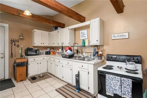 a kitchen with granite countertop a sink stove and cabinets