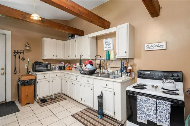 a kitchen with granite countertop a sink stove and cabinets