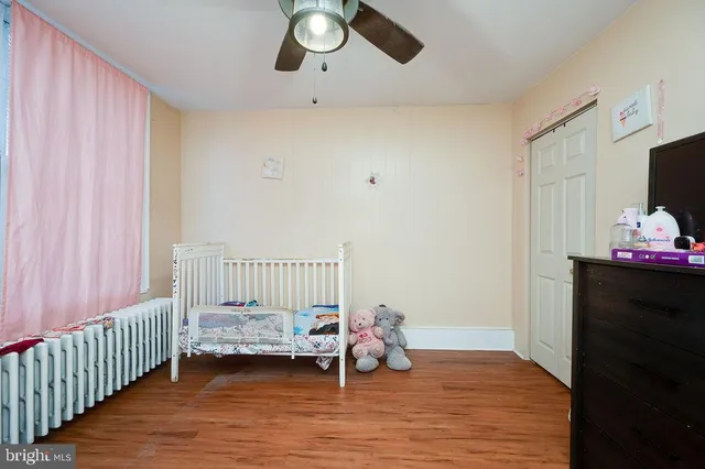 a view of a bedroom with wooden floor and windows