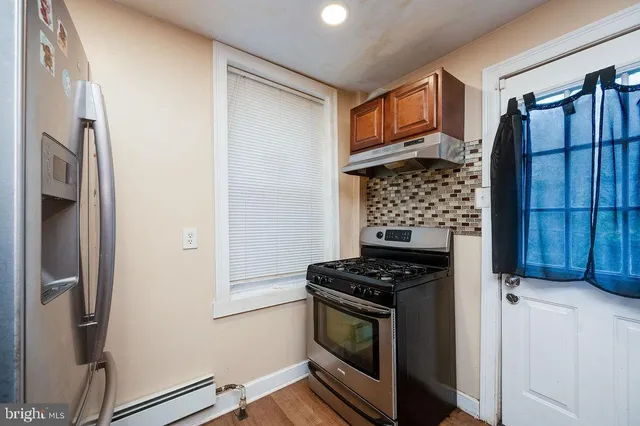a kitchen with stainless steel appliances a refrigerator and a stove top oven