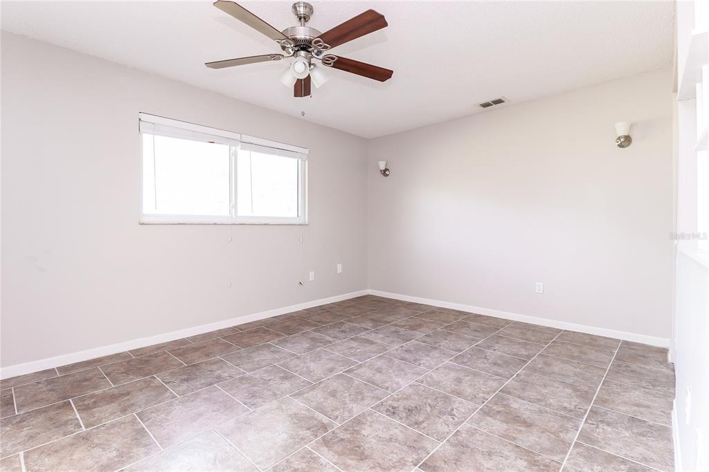 8104 Juarez Drive Port Richey, FL 34668 - Photo 7 of 15 an empty room with a window and a fan
