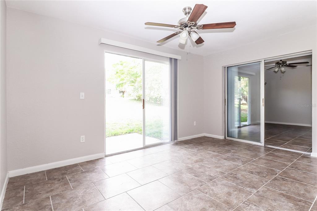 8104 Juarez Drive Port Richey, FL 34668 - Photo 8 of 15 an empty room with chandelier fan and windows